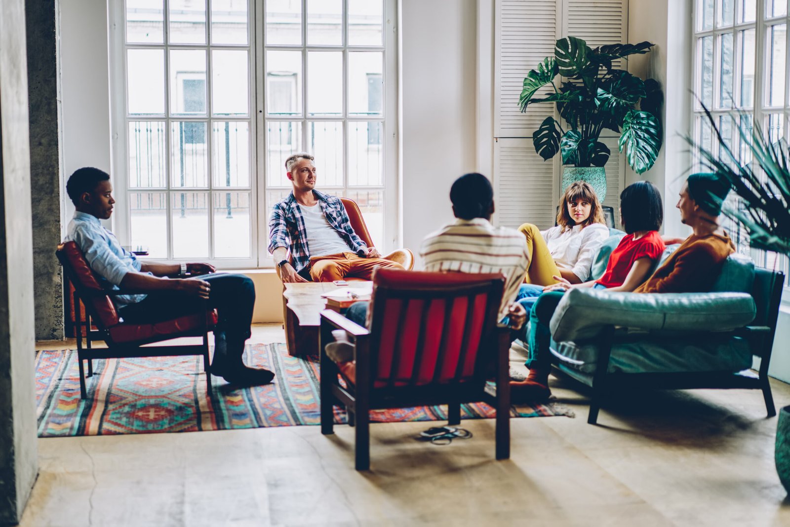 group of delighted multiethnic friends chatting at home